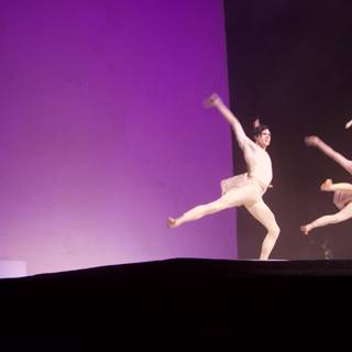 Three Dancers Take the Stage in a Regal Purple Light