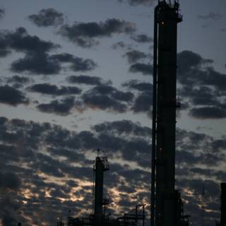 Glowing Refinery Towers Against a Dramatic Sky