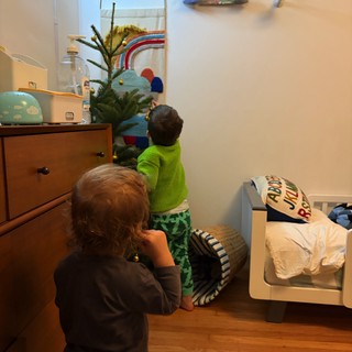 Children Decorating Small Christmas Tree in Bedroom