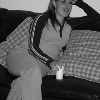 Young Woman Relaxing on Leather Sofa with Drink