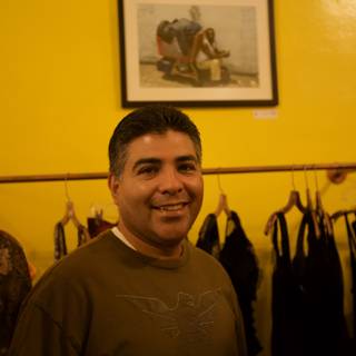 Tony Cardenas Smiling in Front of Clothing Rack