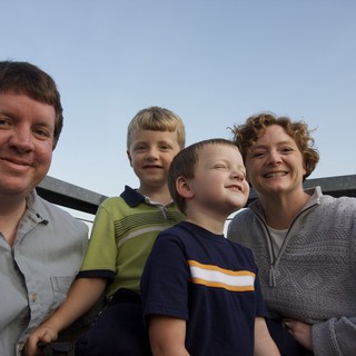 Family of Four Smiling Together on Outdoor Deck