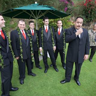 Group of men in suits under an umbrella