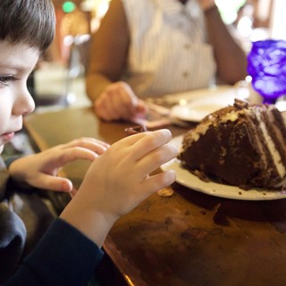 Young Boy Anticipating a Decadent Chocolate Cake