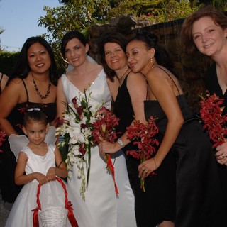Bridal Party Poses with Red Orchid Bouquets Outdoors