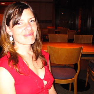 Woman in Red at Dimly Lit Restaurant Table