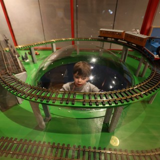 Child Observing Model Train Display in Museum Dome