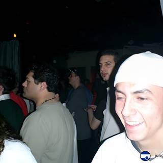 Smiling Man Stands Out in Nightclub Crowd