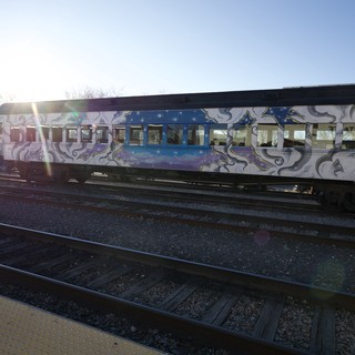 Graffiti-Covered Train Car at Sunset on Railway Tracks