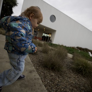 Child Exploring Modern Architecture in Overcast Weather