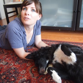 Woman Relaxing on Rug with Black and White Dog
