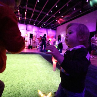 Child Dancing with Glow Stick at Baby Rave Event