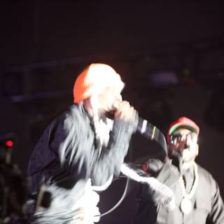 Men with Microphones and a Hat on Stage