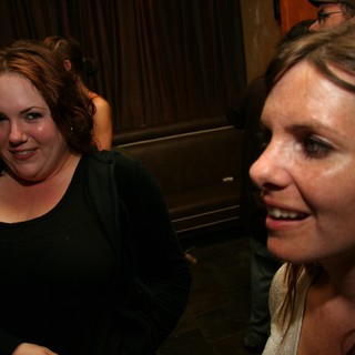 Two Women Laughing Together at a Dark Bar