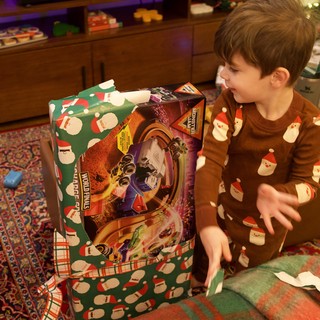 Young Boy Unwrapping Large Christmas Gift