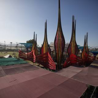 Colorful Flags Flying High in Coachella | Caption: A large tent adorned with colorful flags providing shelter and a vibrant scenery at Coachella 2014 in Indio, United States. The blue sky and waterfront complement the architecture of the tent creating the perfect outdoor experience.