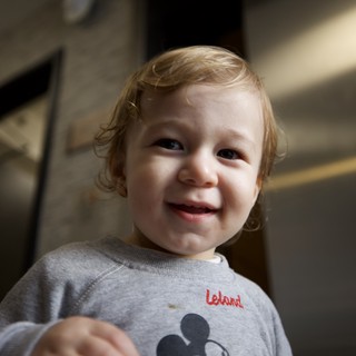 Joyful Toddler in Mickey Mouse Sweatshirt Smiling at Camera