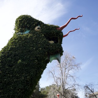 Ivy-Covered Dragon Sculpture Roars Against Blue Sky
