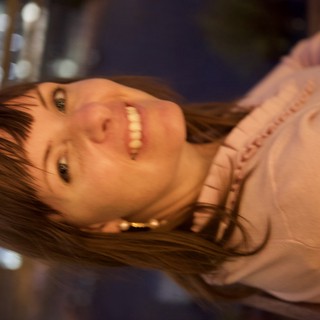 Smiling Woman at Night with City Lights Behind
