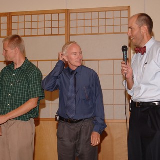 Three Men Share a Moment at Wedding Reception