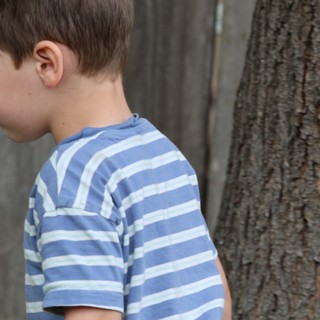 Young Boy in Striped Shirt Near Tree