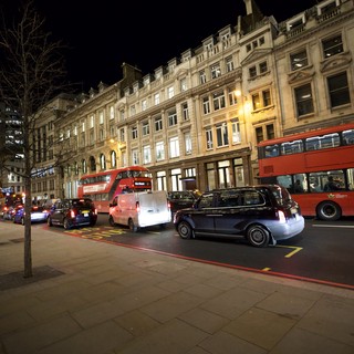 Evening Traffic on London Street with Red Double-Decker Buses