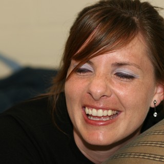 Joyful Woman Laughing Candidly at Indoor Gathering