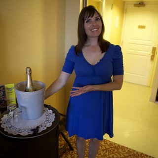 Woman in Blue Dress with Champagne in Hotel Suite