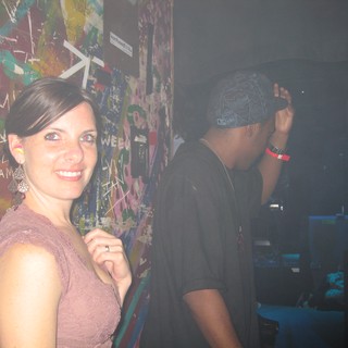 Smiling Woman at Graffiti-Covered Nightclub Wall