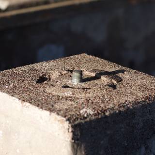 Industrial Heritage: A Rusty Screw on Cement Block