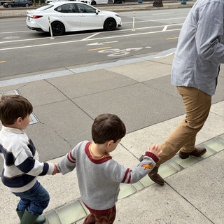 Father and Two Sons Walking on Urban Sidewalk