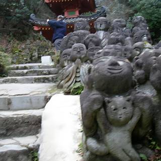 Man Standing Amongst Statues at Temple