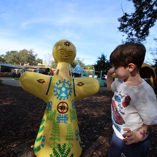 Young Boy Admiring Yellow Decorative Doll at Fantasyland