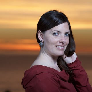 Dark-Haired Woman Smiling at Sunset by Sea