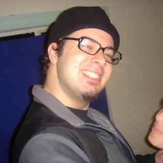 Smiling Man in Black Beanie at Indoor Gathering