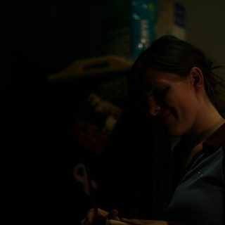Smiling Woman in Dim Light at Evening Event