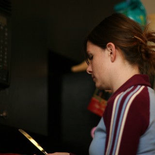 Young Woman Focused in Dimly Lit Kitchen