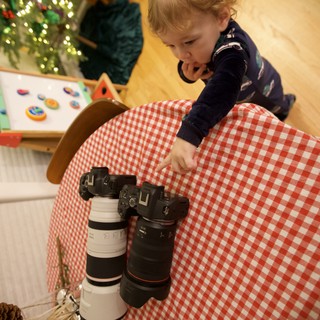 Young Child Exploring Professional Camera Equipment at Christmas