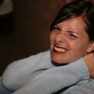 Joyful Woman Laughing Against Brick Wall