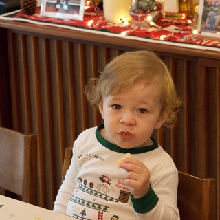 Toddler Enjoying Christmas Cookie in Festive Pajamas