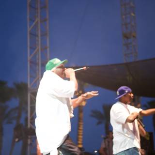 Two Men Performing on Stage Under Blue Skies