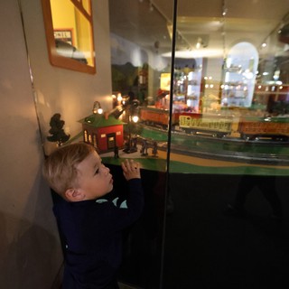 Young Boy Examining Model Train Display at Museum