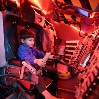 Young Visitor Explores Submarine Periscope Station