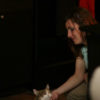 Woman Tenderly Petting a Sleepy Cat at Night