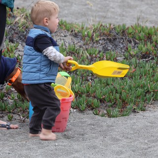 Toddler Ready for Beach Adventure with Colorful Toys