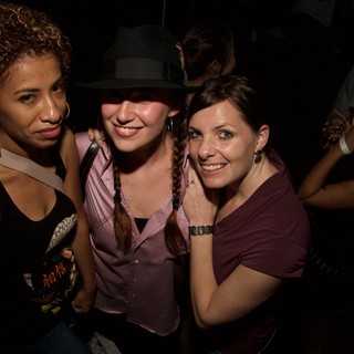 Three Friends Posing Together at a Nightclub Event