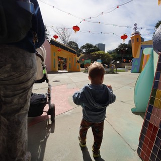 Young Child Exploring Colorful Plaza with Red Lanterns