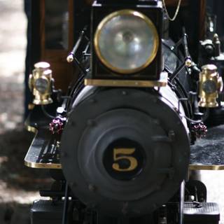 Black and Gold Locomotive Steaming Down the Tracks