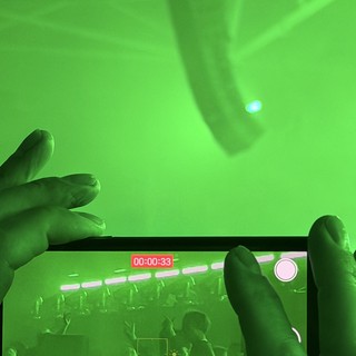 Recording a Concert Through Phone Screen in Green Stage Lighting