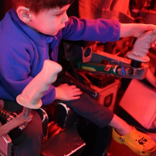 Young Boy Exploring Interactive Science Exhibit Under Red Light